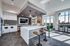 Interior view of AMLI Frisco Crossing apartment sky lounge kitchen with island, pendant lights, bolted barstools, and stainless appliances.