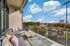 Balcony lounge area with plush sectional sofa, throw pillows, coffee table, and stadium views at AMLI Frisco Crossing apartments.