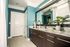 Interior view of a bathroom at AMLI Joya apartment with double sink vanity, large mirror on wall and granite counters.