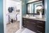 Interior view of a bathroom at AMLI Joya apartment with double sink vanity, large mirror on wall and granite counters.