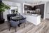 Living area at AMLI Joya apartments with contemporary decor, teal sofa with accent pillows and dining table with chairs.