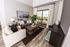An apartment living room at AMLI Joya with cool neutral colors, a couch and coffee table and kitchen island with stools.