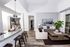 An apartment living room at AMLI Joya with cool neutral colors, a couch and coffee table and kitchen island with stools.