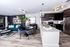 Living area at AMLI Joya apartments with contemporary decor, teal sofa with accent pillows and dining table with chairs.