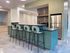 Contemporary kitchen with sleek green cabinetry, stylish bar stools, and modern stainless steel appliances.