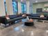 Modern apartment lounge showcasing a stylish black sectional sofa with colorful cushions, complemented by a sleek round coffee table.