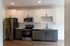 Modern kitchen with sleek stainless steel appliances, elegant cabinetry, and stylish wood flooring.