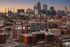 Vibrant urban skyline at sunset showcasing modern high-rise buildings and a lively cityscape.