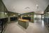 Modern apartment mailroom featuring sleek green paneling, individual mailboxes, and a stylish central wooden counter.
