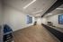 Contemporary exercise room with sleek hardwood floors, large mirror wall, and neatly organized fitness equipment including yoga mats and stability balls.