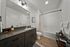 Modern bathroom with sleek dark cabinetry, elegant lighting, and a stylish tiled shower area.