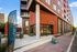 Modern apartment building with vibrant facade, featuring leasing banners and tour signage, inviting new residents.