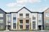 Modern apartment building exterior with elegant gray and white siding, large windows, and a welcoming entrance surrounded by greenery.