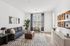 Chic and modern living room with a stylish gray sofa, elegant decor, and abundant natural light flooding through large windows, creating an inviting atmosphere.
