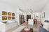 Modern apartment living area with stylish open-concept kitchen, featuring sleek appliances, minimalistic decor, and elegant lighting. Inviting space with artistic wall pieces and comfortable seating.