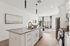 Modern open-concept kitchen with sleek countertops, adjacent to a bright and airy living room with stylish decor.