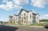 Modern apartment complex with contemporary architecture, featuring stylish balconies and ample parking space, under a bright blue sky.
