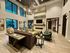 Luxurious living room with modern decor, featuring plush seating, large windows, and a stylish chandelier.