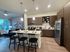 Modern kitchen with sleek cabinetry, spacious island with seating, and an adjacent cozy living area.