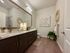 Elegant bathroom with dark wood cabinets, marble countertop, and modern decor.