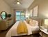 Bright and cozy bedroom with plush bedding, a ceiling fan, and elegant decor.