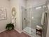 Contemporary bathroom with glass shower, earthy decor, and modern accents.