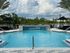 Inviting pool area at Integra Avalon, featuring crystal-clear water, upscale lounge chairs, and lush green surroundings for a perfect relaxing retreat.