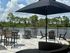 Chic lakeside patio featuring cozy seating, stylish umbrellas, and scenic water views, ideal for relaxation and entertainment.