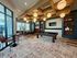 Chic recreational lounge featuring a billiards table, modern lighting, and comfortable seating with large windows offering natural light.
