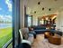 Modern living room with a large blue sectional sofa, stylish table, and expansive windows offering serene lake views, perfect for relaxation and entertaining.