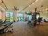 Modern fitness center with state-of-the-art equipment, bright natural lighting, and scenic outdoor views.