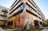Vibrant urban apartment building with eye-catching floral mural, offering creative and inviting exterior design.