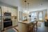 Contemporary open-concept kitchen and living area featuring modern appliances, stylish pendant lighting, and a cozy sitting space with abundant natural light.