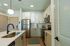 Modern apartment kitchen with sleek stainless steel appliances, elegant white cabinetry, and a stylish island sink, perfectly blending functionality with contemporary design.