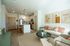 Bright and modern open-concept living area featuring a cozy sofa, stylish kitchen with island, and elegant pendant lighting.