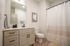 Elegant bathroom with modern vanity, sleek fixtures, and cozy ambiance, enhanced by stylish decor and warm lighting.