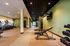 Modern fitness center with sleek workout equipment, featuring treadmills, weight benches, and a vibrant green ambiance.