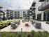 Modern apartment complex courtyard featuring elegant patio furniture, lush landscaping, and a serene atmosphere.