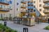 Modern apartment courtyard featuring stylish outdoor seating, built-in barbecue grill, and elegant landscaping for a welcoming community space.