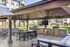 Inviting outdoor pavilion with modern barbecue setup and stylish dining area, perfect for entertaining in a lush residential community.