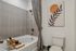 Elegant bathroom with a modern bathtub, artful decor, and soothing color palette, offering a relaxing sanctuary.
