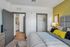 Inviting bedroom featuring modern decor, plush bedding, and a vibrant accent wall. Spacious walk-in closet and soft lighting create a cozy atmosphere.