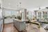 Bright and modern open-concept kitchen and living area with granite countertops, stylish lighting, and large windows offering abundant natural light.