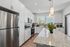Modern kitchen with sleek stainless steel appliances, elegant granite countertops, and bright natural lighting.