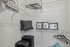 Modern apartment closet with sleek wire shelving, stylish framed art, cozy pillows, and ample storage space for luggage.