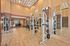 Modern apartment gym featuring state-of-the-art fitness equipment, hardwood flooring, and elegant lighting.