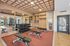 Modern and spacious fitness center with state-of-the-art equipment, mirrored walls, ample natural light, and sleek wooden accents.