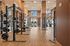 Modern fitness center with state-of-the-art equipment, bright natural lighting, and stylish wood flooring, offering a perfect workout environment.
