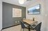 Modern meeting room with elegant art, stylish wallpaper, and scenic mountain view on smart TV, complemented by sleek table and chairs.