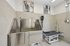Modern pet grooming station with a stainless steel wash basin and adjustable grooming table, highlighted by stylish pet-themed artwork on the walls.